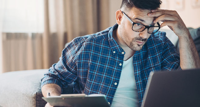 A man checking laptop in worried and tension state Image